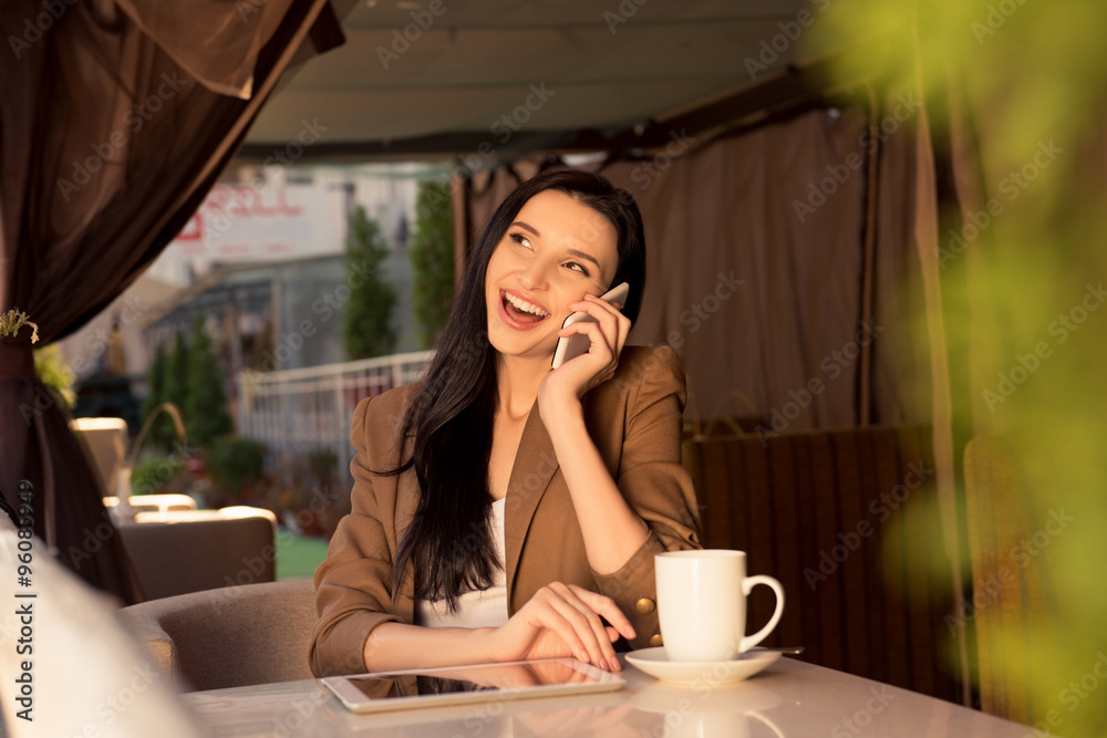Cute young business woman in a cafe talking on the phone Cute young business woman in a cafe talking on the phone