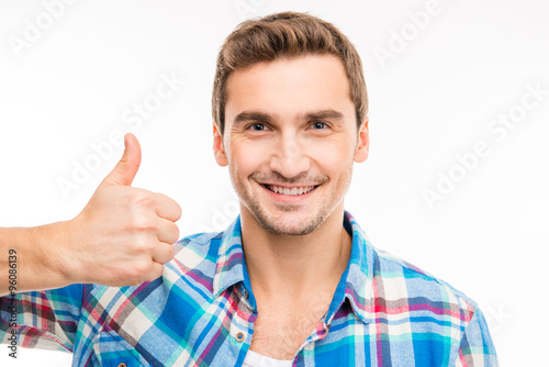 Portrait of a cute handsome young man showing thumb up