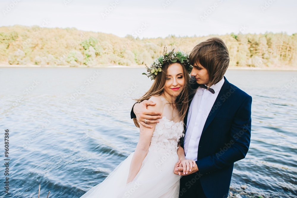 beautiful young couple just married on a walk by the lake beautiful young couple just married on a walk by the lake