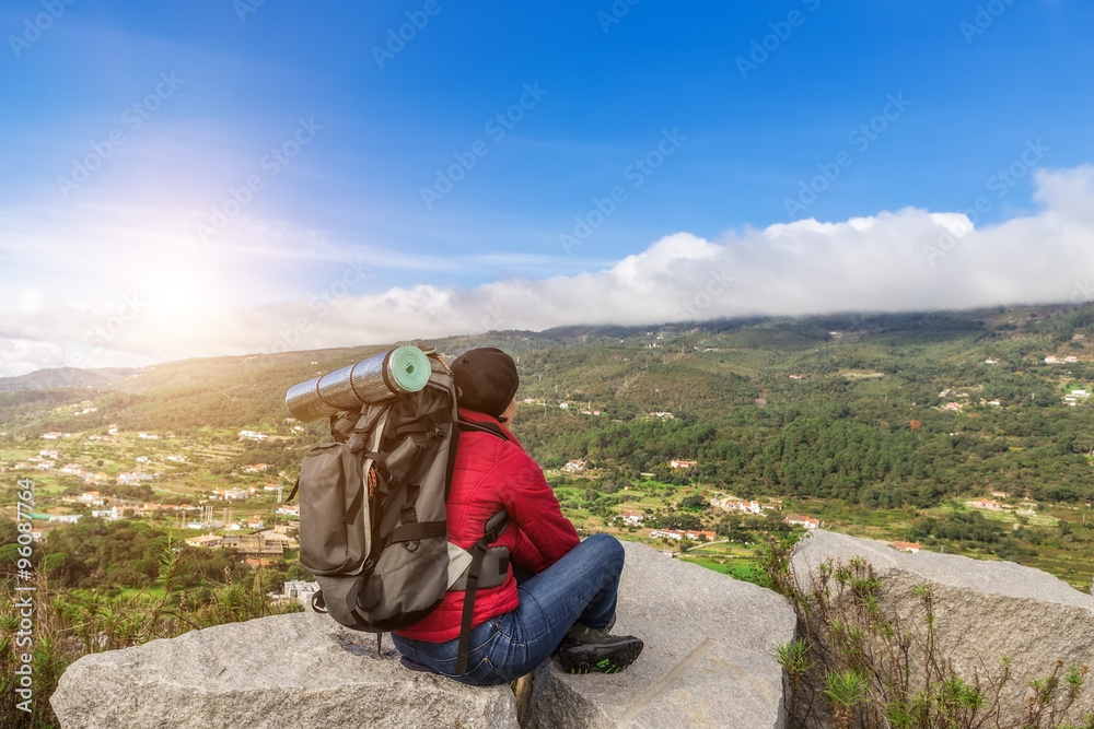 Girl tourist with a backpack resting in a campaign. With views of the Monchique.