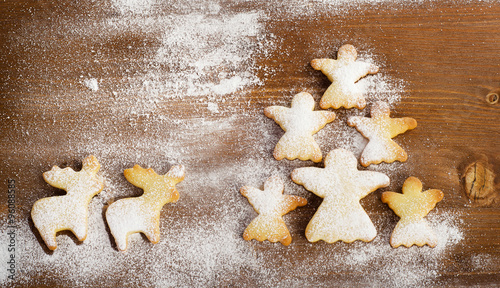 Christmas tree of homemade angel cookies on a wooden background.