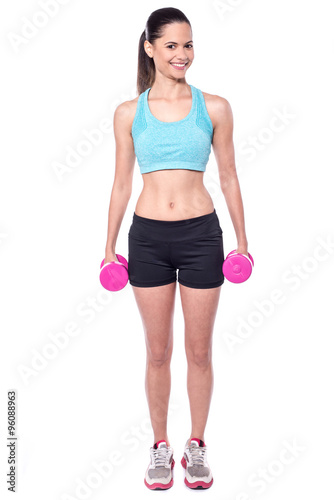 Young instructor posing with dumbbells