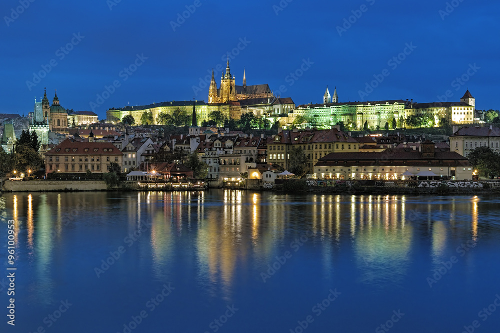 Prague, Czech Republic. Evening view of the Prague Castle with St. Vitus Cathedral and Mala Strana district with St. Nicholas Church and Mala Strana Bridge Towers from the shore of Vltava river.
