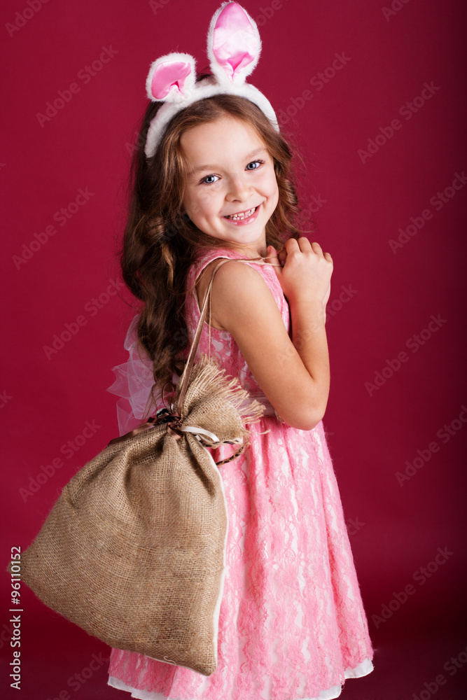 Child girl with gift bag is wearing bunny ears 