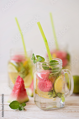 Lemonade with lime and watermelon in a glass jar with a handle 