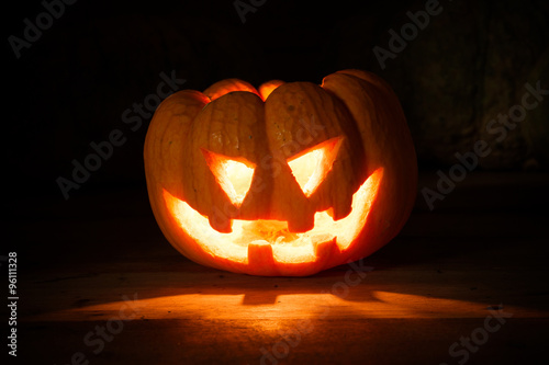 Bright light in pumpkins on wood and pumpkins background by dark