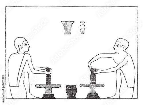 Two potters shaping an article on the wheel, vintage engraving.