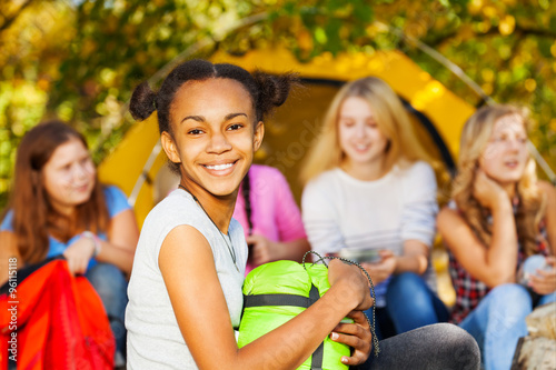 African happy girl holding green sleeping bag