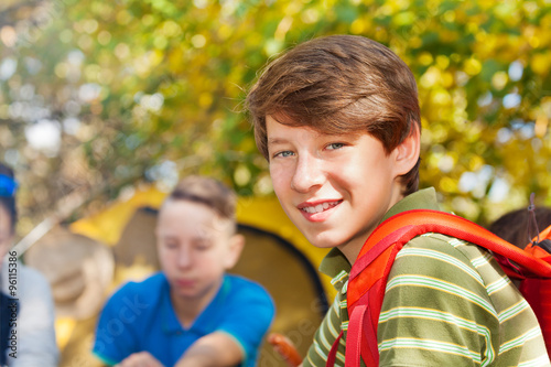Close-up of boy with rucksack near yellow tent