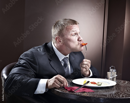 Muscular businessman eating
