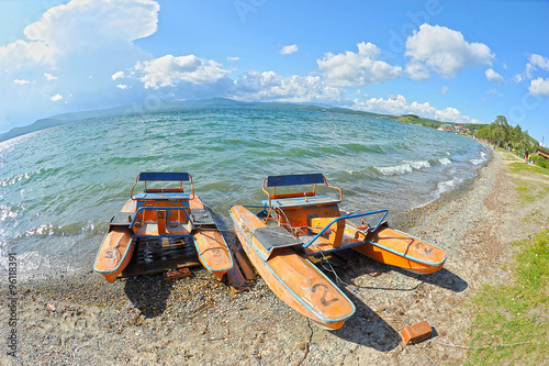 old catamaran on the shore near the lake photo