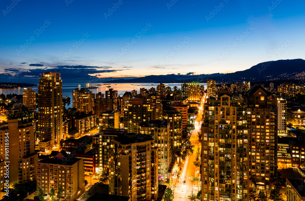 Vancouver, Canada at night. Sparkling aerial view of downtown and bay under deep blue sky.