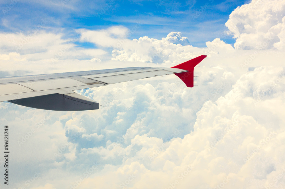 Fototapeta premium selective focus wing of plane on cloud and beautiful blue sky.