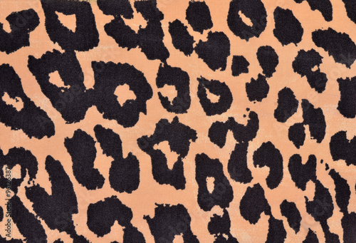 Black and orange leopard fur pattern. Spotted animal print as background.