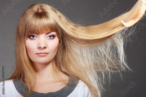 Blonde woman with her damaged dry hair.