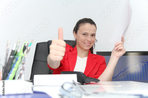 Pretty Business woman analyzing investment charts with calculato photo