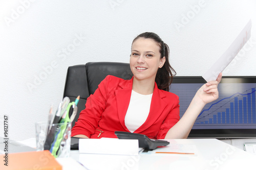 Pretty Business woman analyzing investment charts with calculato photo