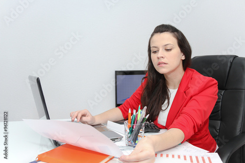 Pretty Business woman analyzing investment charts with calculato photo