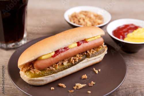 Hotdog mit Gurke, Zwiebeln, Ketchup und Senf