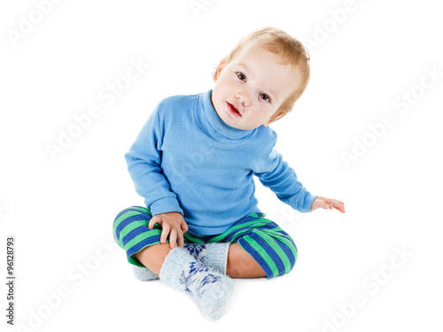 Cute happy baby blonde in a blue sweater playing and smiling on white