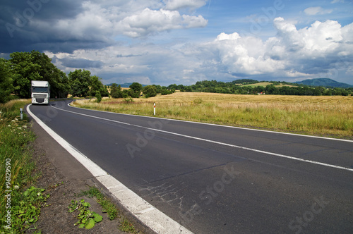 Cuadro en lienzo The asphalt road in rural countryside with dramatic clouds in the sky