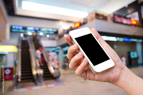 woman hand holding the phone tablet on blur event background photo