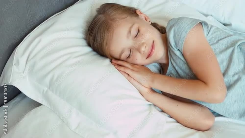 Girl wakes up in a bed and smiling at camera Girl wakes up in a bed and smiling at camera