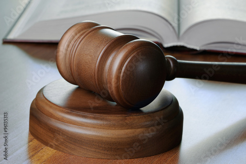 Gavel and opened book on wood table