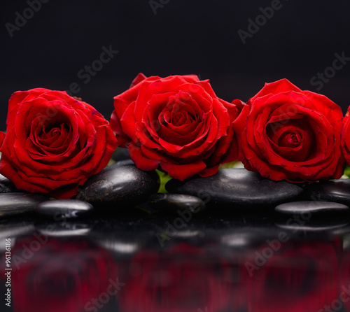Still life with three red rose and therapy stones