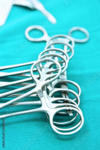 Detail shot of steralized surgery instruments with a hand grabbing a tool take with art lighting and blue filter 