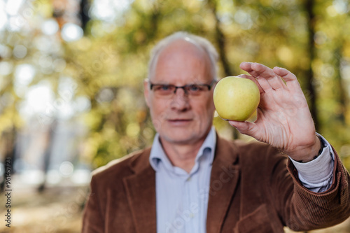 senior adult holding green apple photo