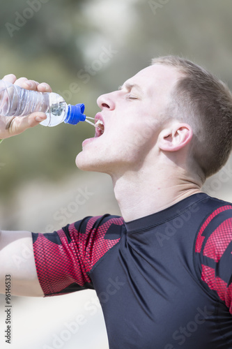 male runner drinking water