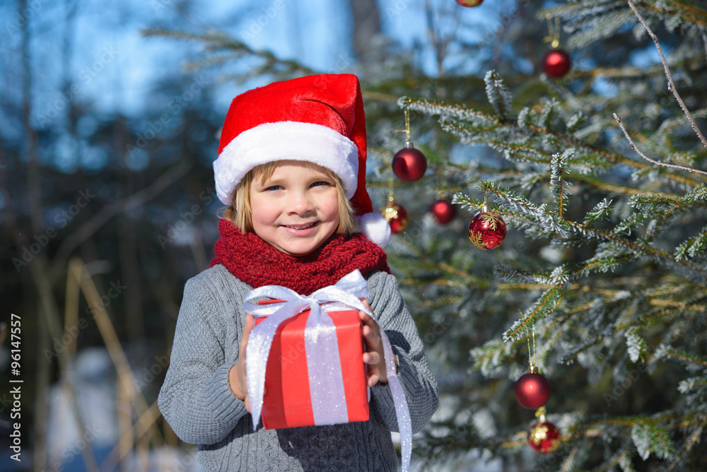 Portrait of smiling little boy with christmas gift in winter forest Portrait of smiling little boy with christmas gift in winter forest