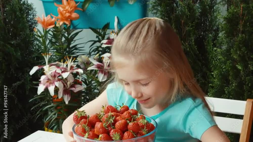 Girl with a big plate of strawberries looking at camera and smiling. Thumb up. Ok Girl with a big plate of strawberries looking at camera and smiling. Thumb up. Ok