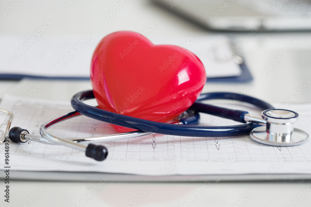 Stethescope and red heart lying on cardiogram Stethescope and red heart lying on cardiogram