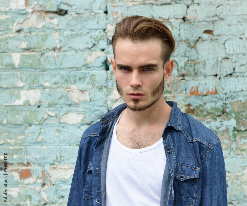 Portrait of young handsome man looking at camera outdoor against Portrait of young handsome man looking at camera outdoor against