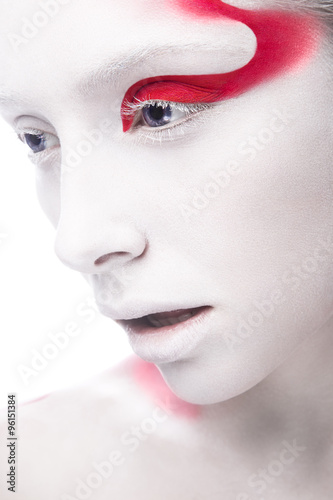 Art fashion girl with white skin and red paint on the face. Creative art beauty