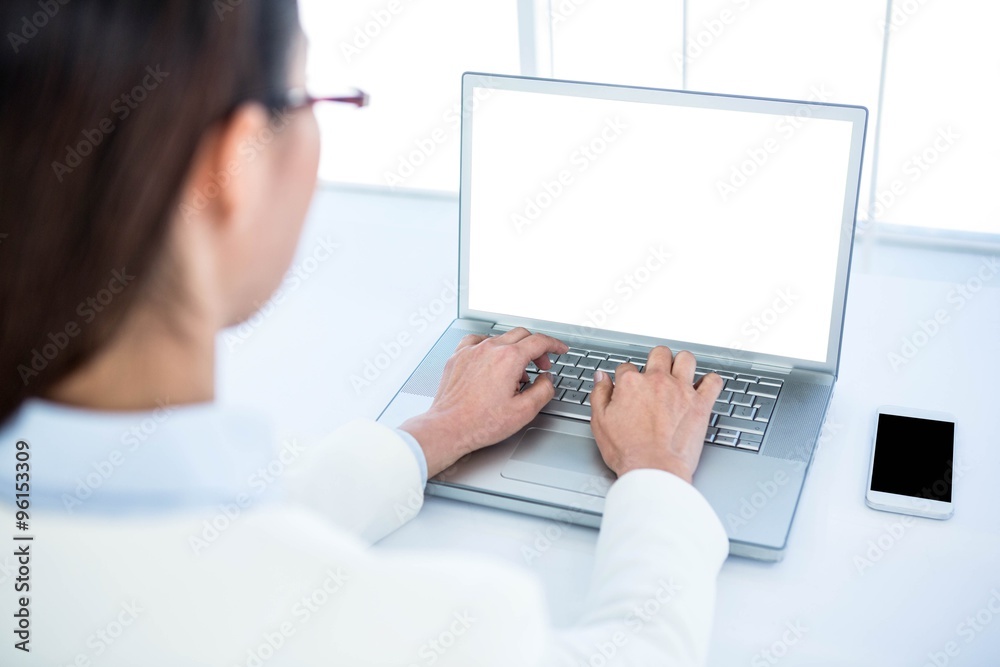 Fototapeta premium Rear view of businesswoman using laptop 