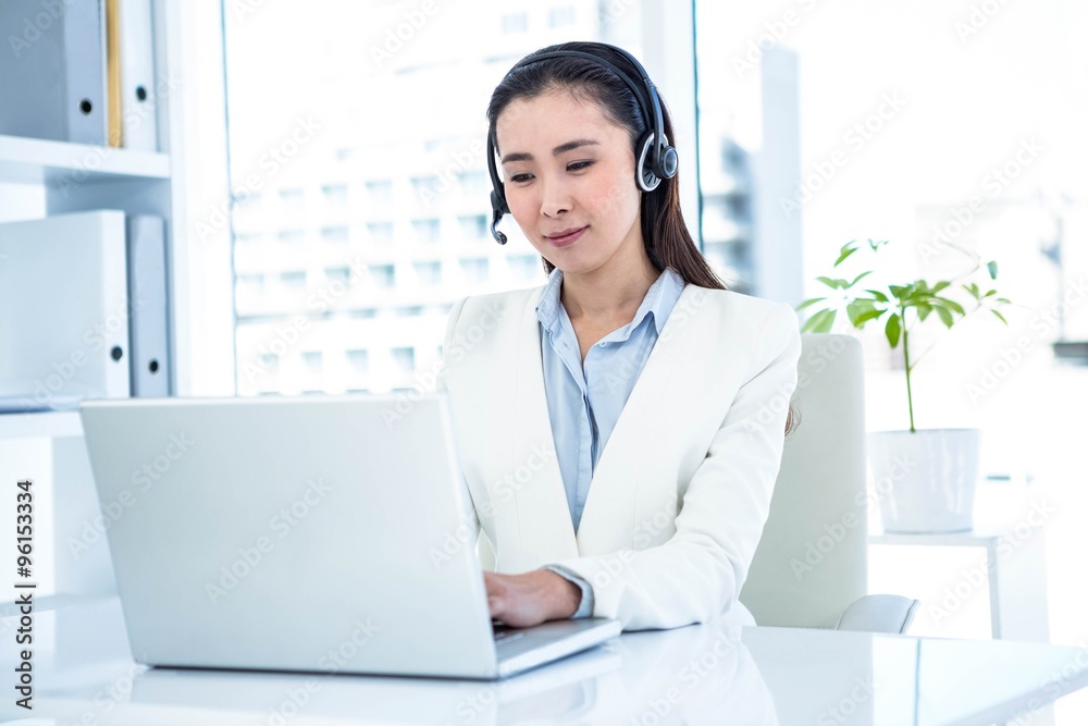 Smiling businesswoman with headset using laptop Smiling businesswoman with headset using laptop
