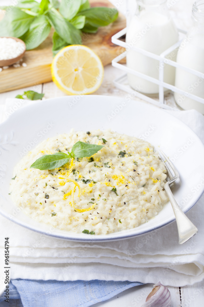 Risotto with lemon and fresh basil. White wooden background Risotto with lemon and fresh basil. White wooden background