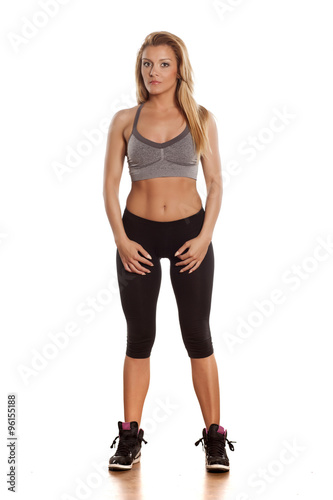 pretty athletic blonde posing in a studio on white