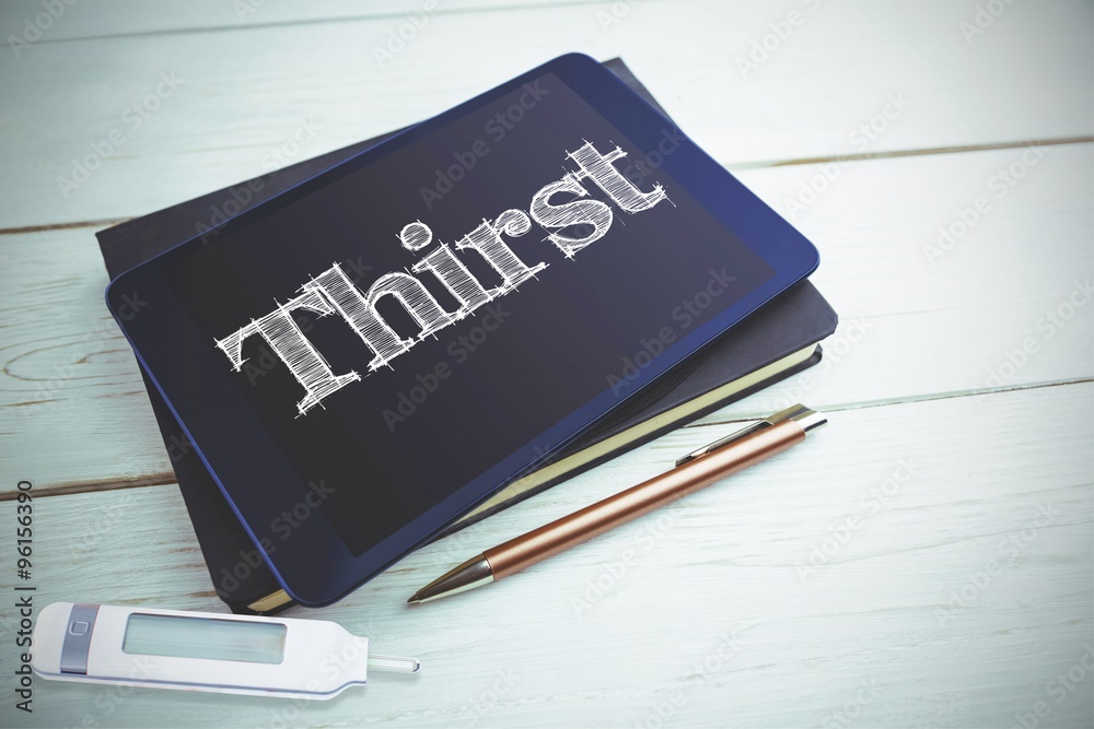 Thirst against view of a book and tablet lying on desk Thirst against view of a book and tablet lying on desk