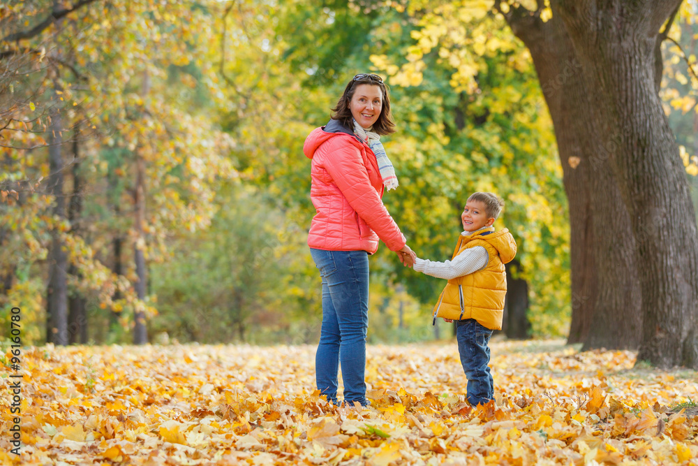 Adorable boy with his mother in autumn park Adorable boy with his mother in autumn park