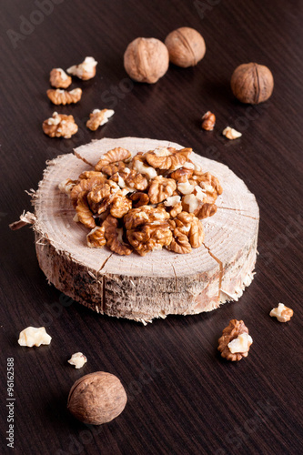 Walnut kernels and whole walnuts on wooden table
