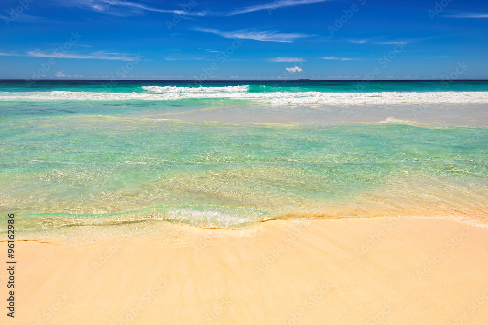 Fototapeta premium Blue sea, white sund on beach. Seychelles island.