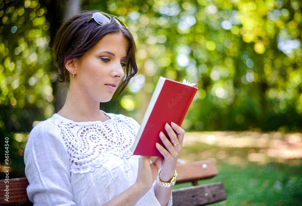 Woman reading an interesting book in the park Woman reading an interesting book in the park