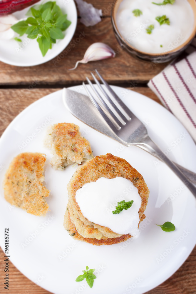 Fried potato pancakes with oatmeal and basil on a white ceramic plate. Fried potato pancakes with oatmeal and basil on a white ceramic plate.