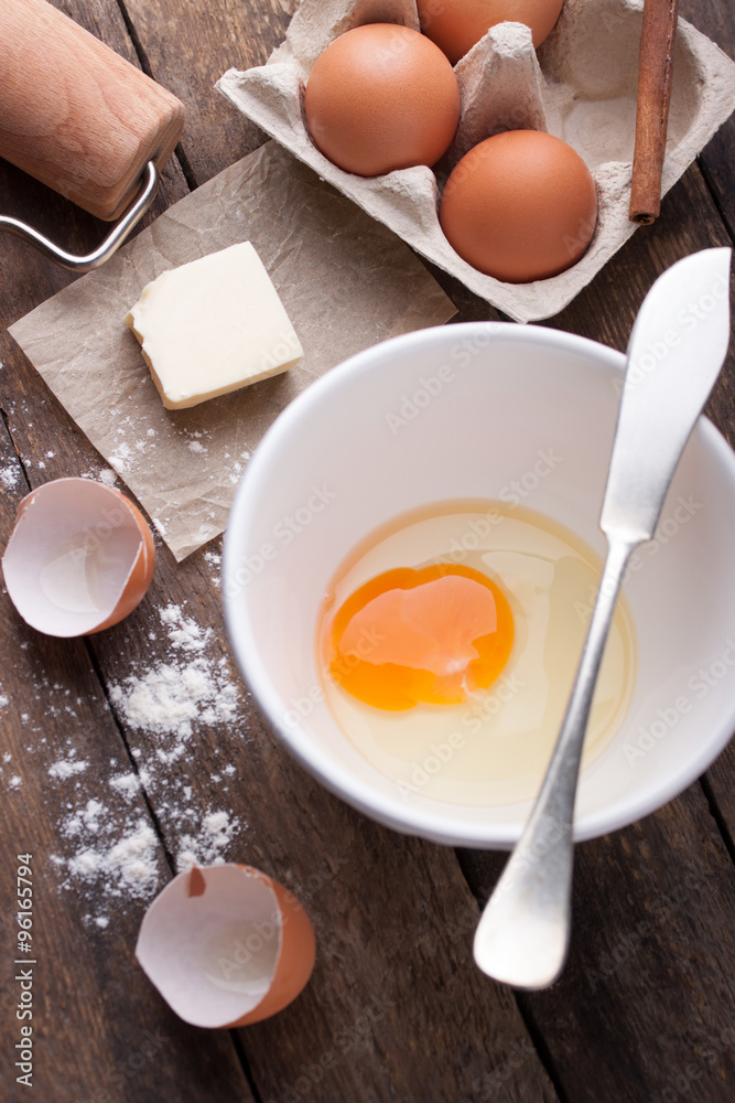 Ingredients and tools ready to make a cake, flour, eggs, butter, cinnamon stick on a wooden table. Selective focus Ingredients and tools ready to make a cake, flour, eggs, butter, cinnamon stick on a wooden table. Selective focus