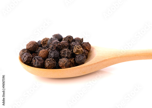 black pepper in wooden spoon solated on white