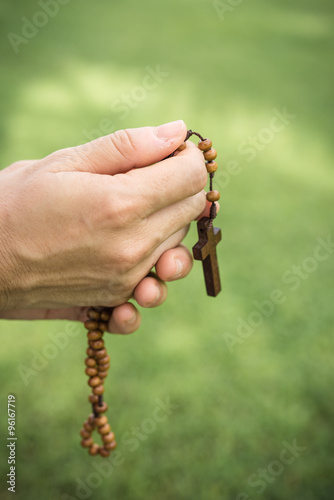 Woman hands praying with a rosary
